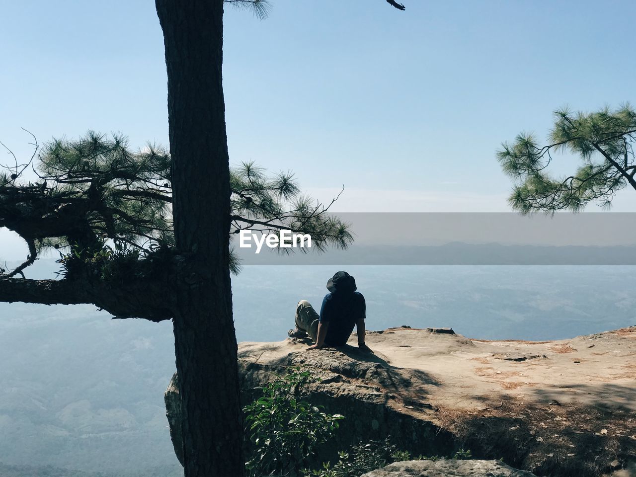 People sitting on shore against sky