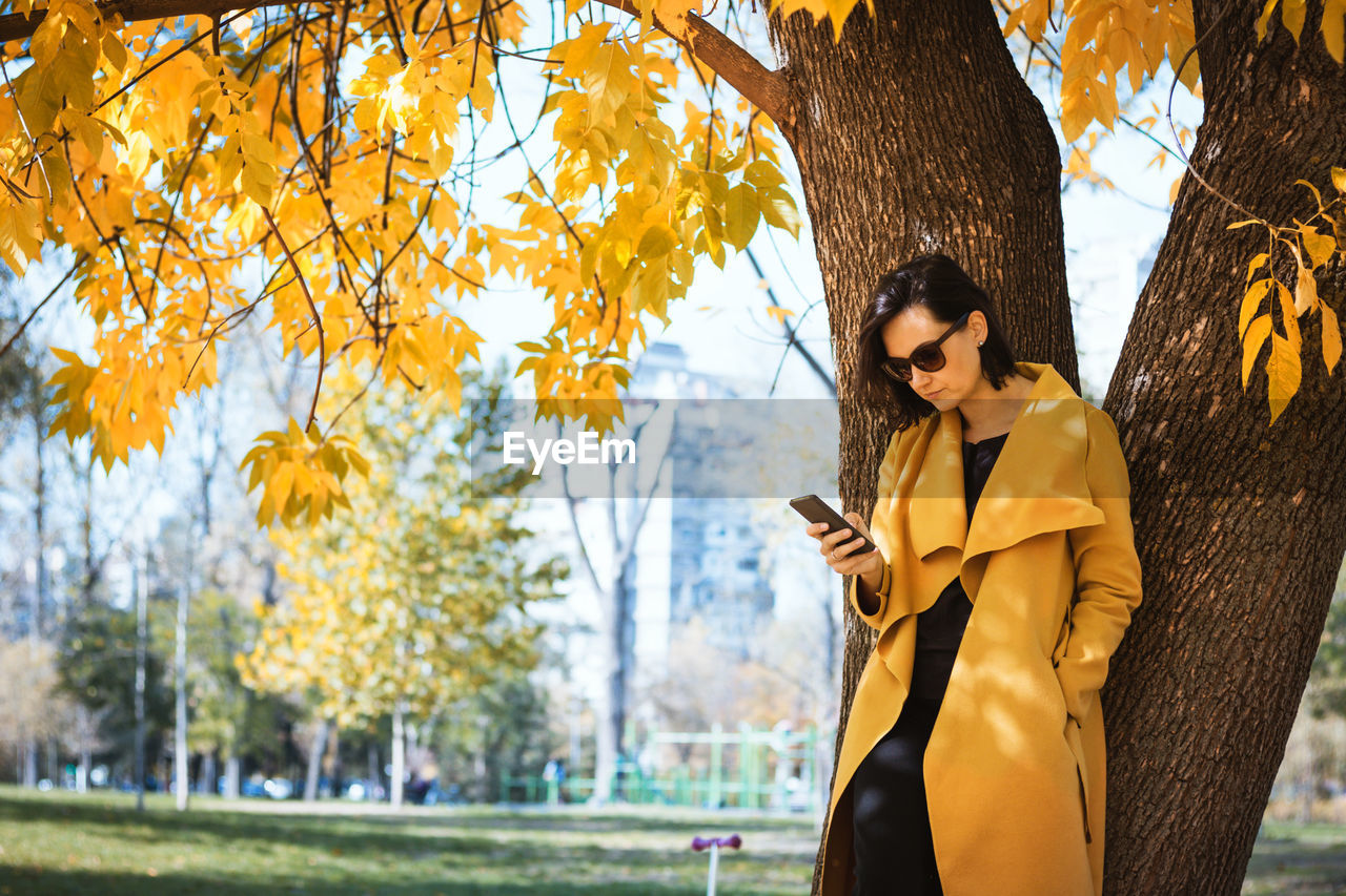 Beautiful woman using smart phone at public park