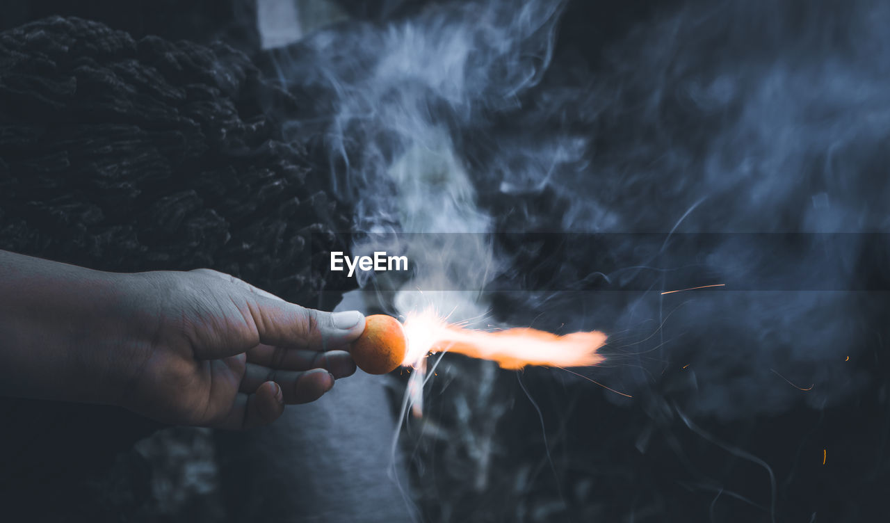 Cropped hand of person holding firework