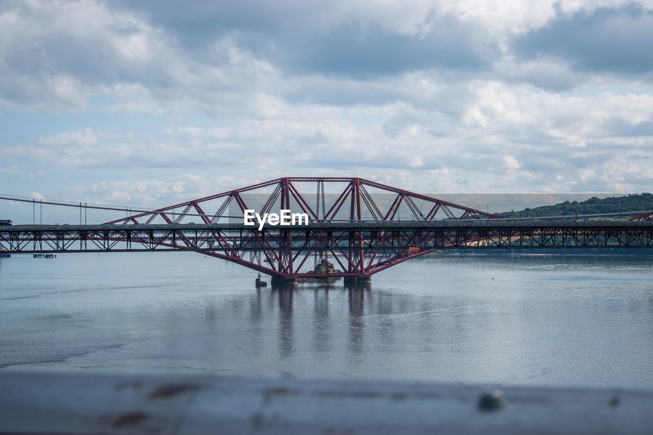 Bridge over river against cloudy sky