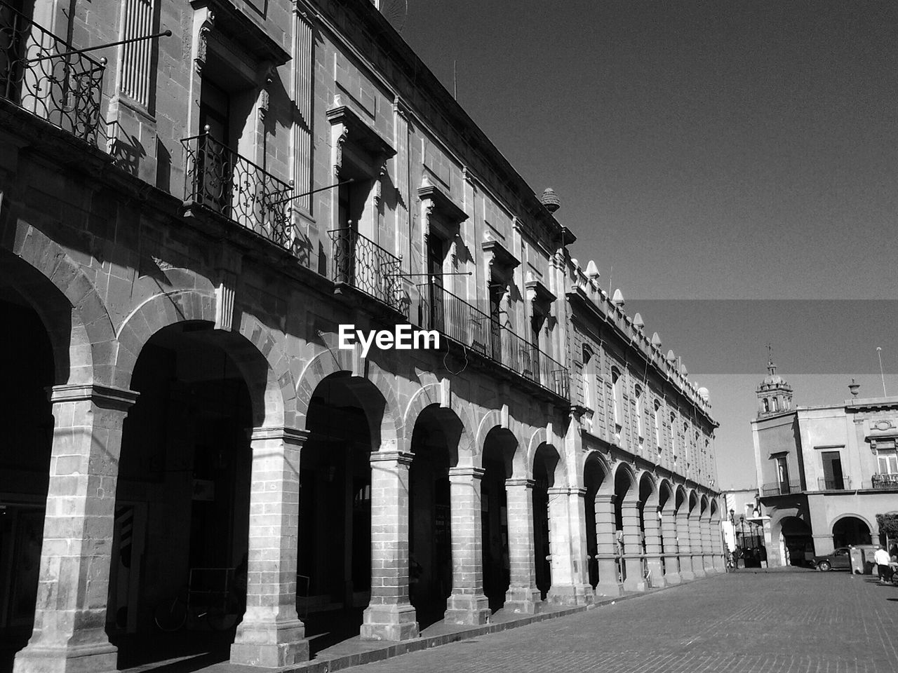 Street by buildings against clear sky