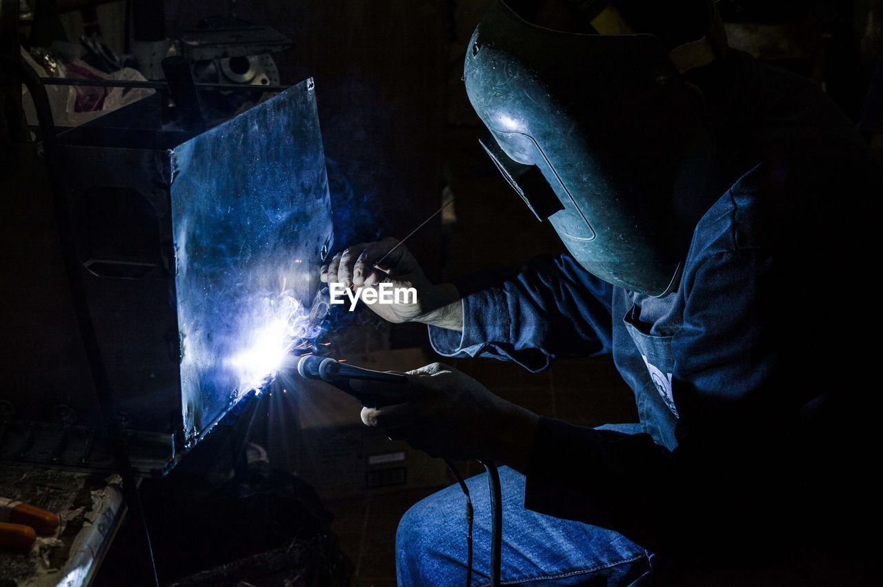 Man welding metal in workshop