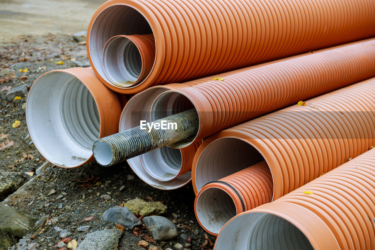 Stack of metallic pipes on land