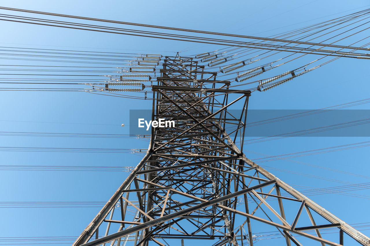 low angle view of electricity pylon against blue sky