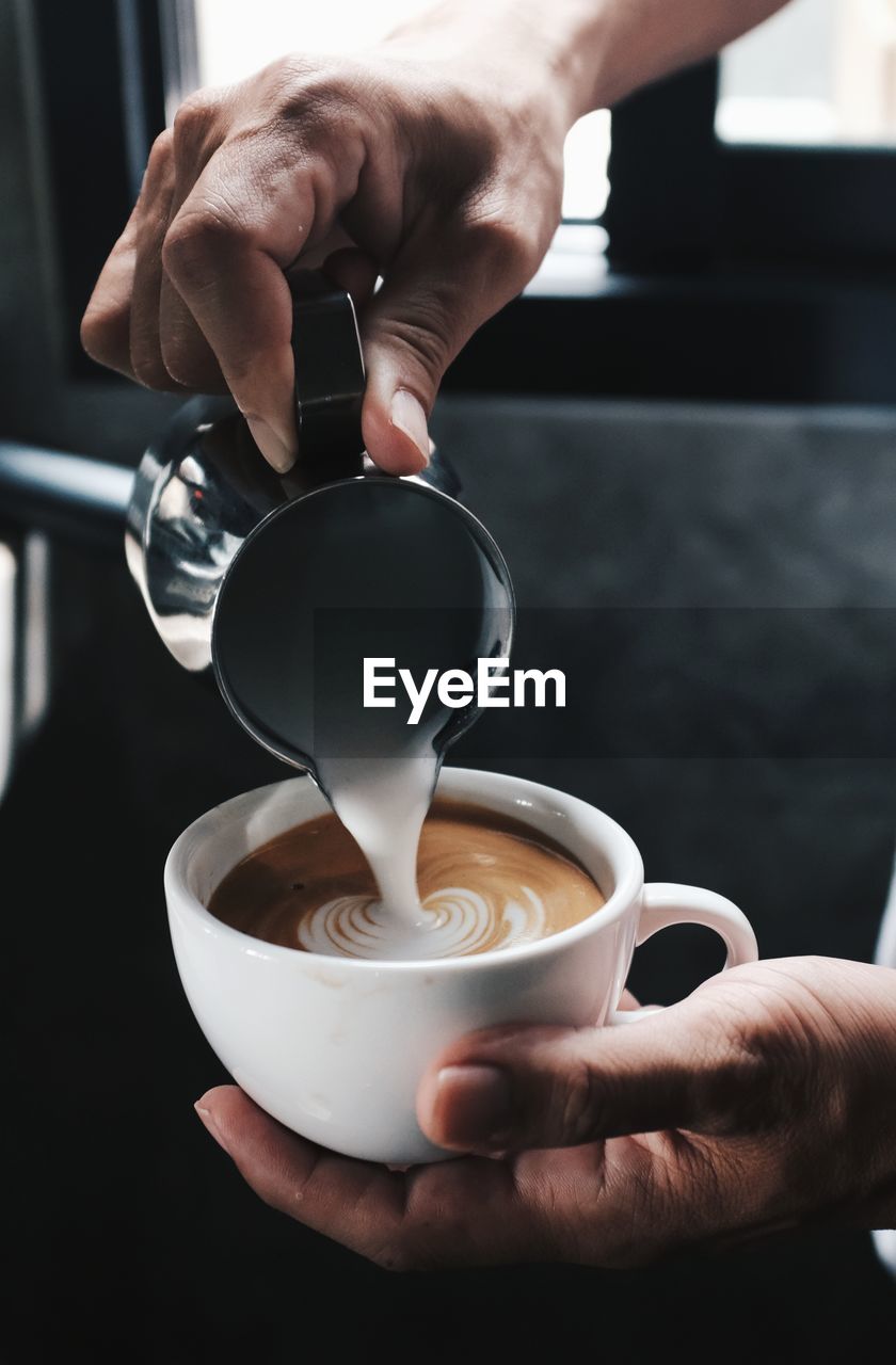 Close-up of hand holding coffee cup