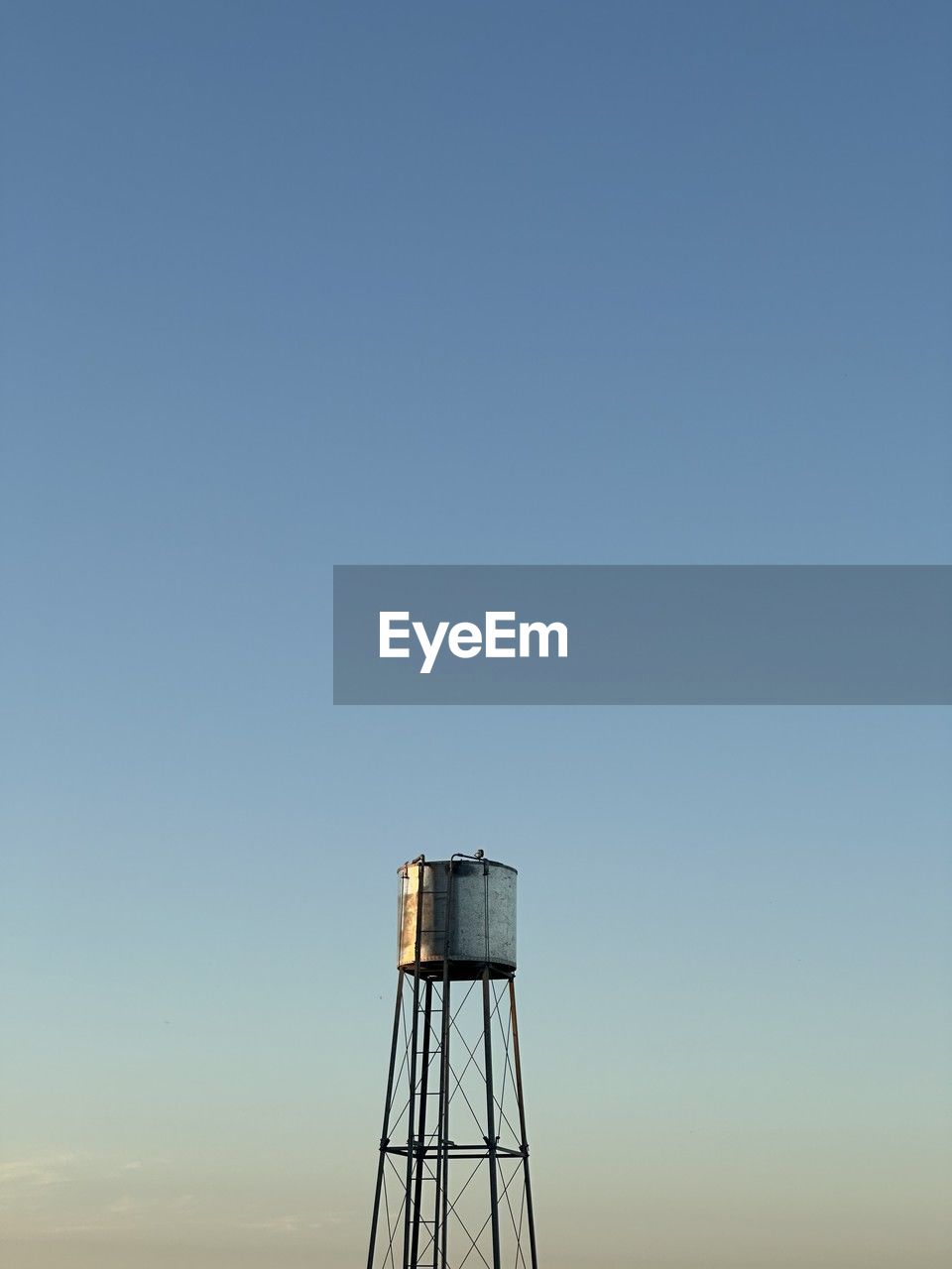 Low angle view of a field water tank against clear sky