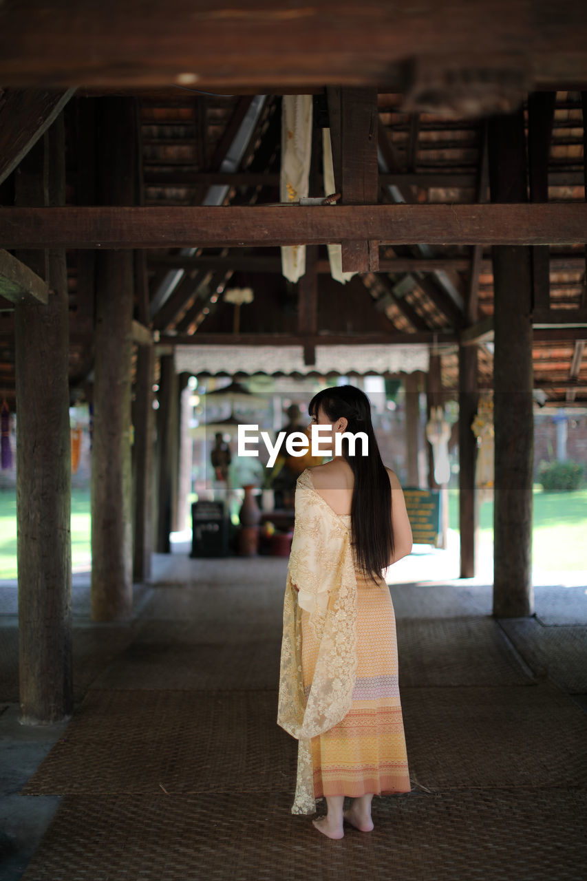 Rear view of woman standing in temple