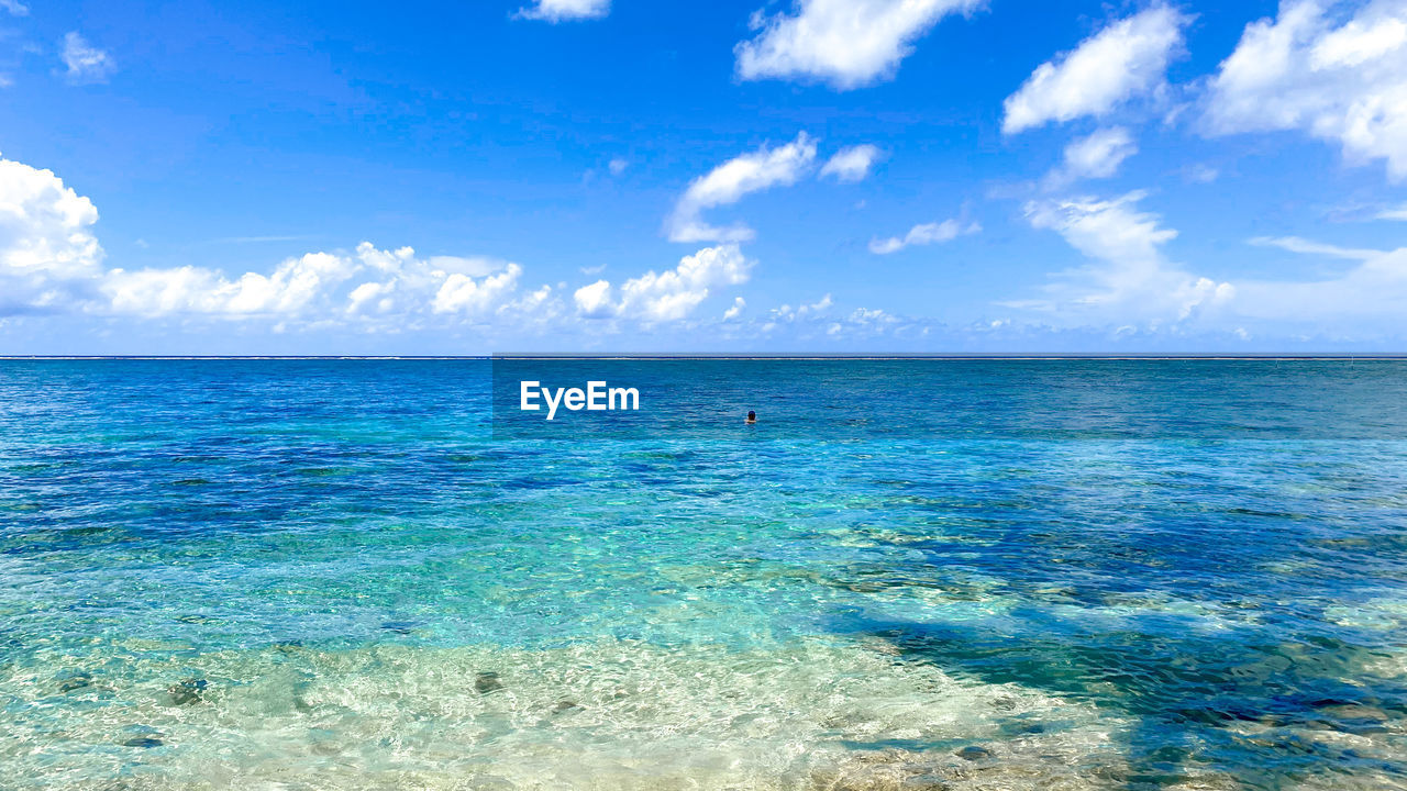 water, sea, sky, beauty in nature, scenics - nature, blue, land, nature, cloud, horizon, tranquility, ocean, travel, tranquil scene, horizon over water, tropical climate, travel destinations, shore, body of water, beach, turquoise colored, idyllic, vacation, holiday, environment, trip, wind wave, day, summer, tourism, seascape, landscape, outdoors, island, no people, coast, sunlight, transparent, lagoon, azure, urban skyline, sunny, relaxation, sand, wave