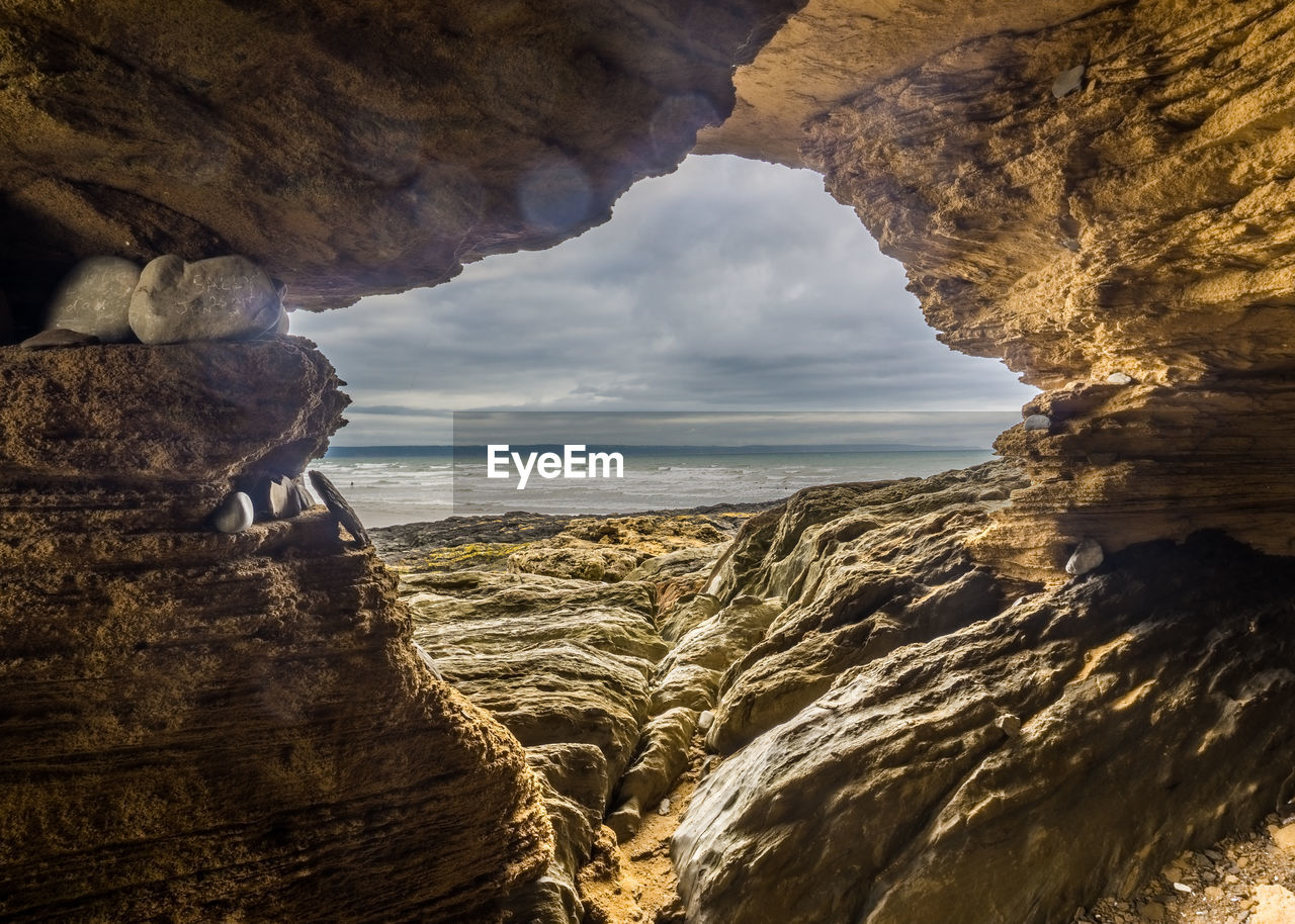 Scenic view of sea seen through rock formations against sky