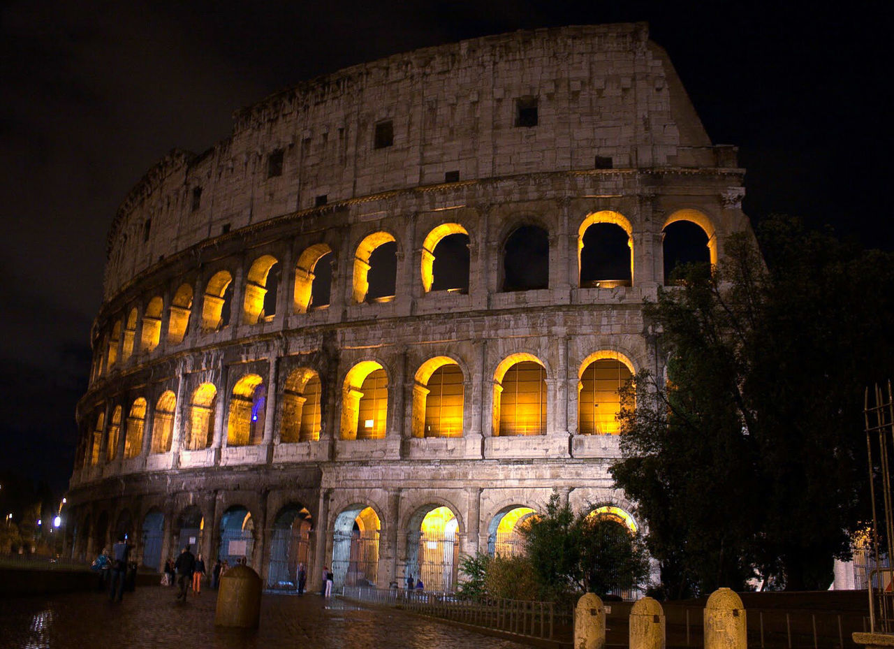 People in front of coliseum at night