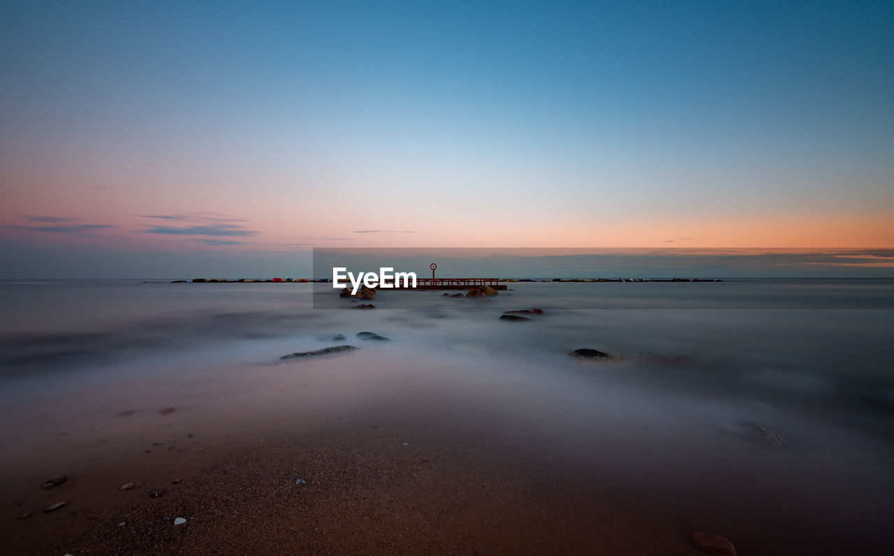 Scenic view of beach against sky during sunset