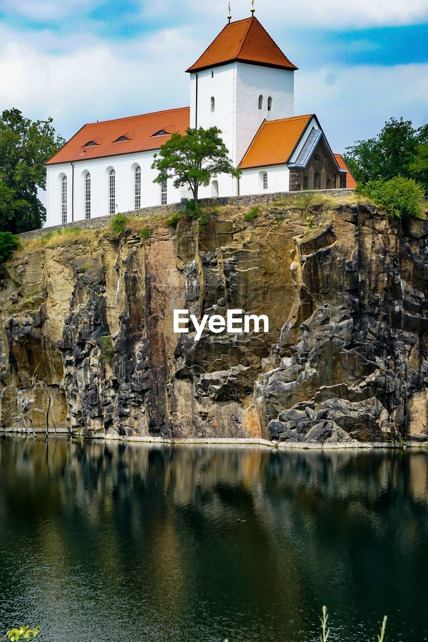 Houses by lake against sky