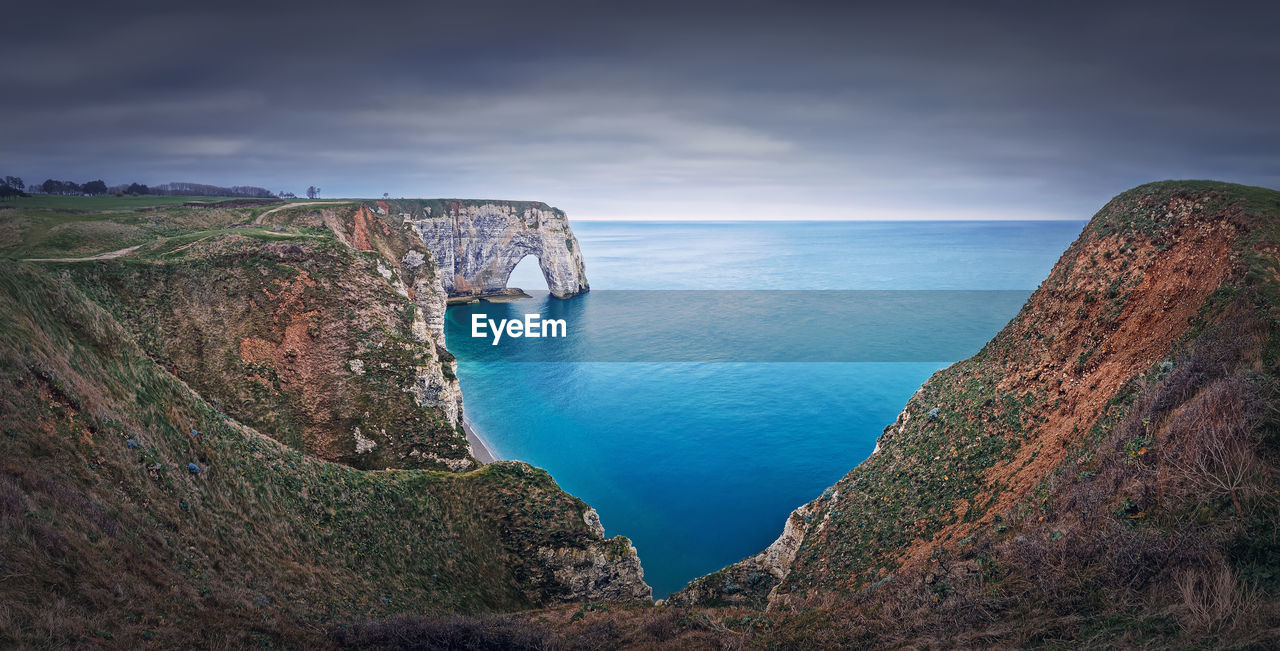 water, sea, cliff, land, coast, scenics - nature, beach, sky, terrain, rock, beauty in nature, nature, cloud, environment, coastline, landscape, travel destinations, ocean, horizon over water, bay, body of water, travel, tranquility, horizon, seascape, tranquil scene, no people, outdoors, mountain, rock formation, reflection, tourism, non-urban scene, island, day, blue, trip, idyllic, holiday