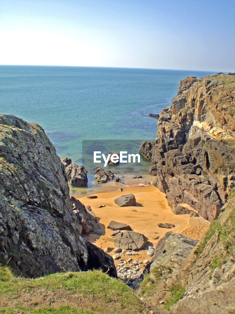 SCENIC VIEW OF SEA BY CLIFF AGAINST CLEAR SKY