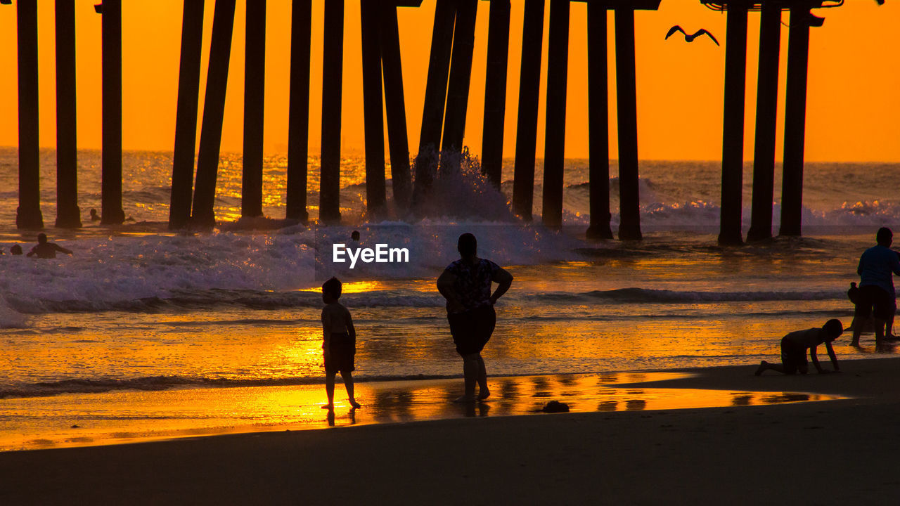 SILHOUETTE PEOPLE AT BEACH DURING SUNSET