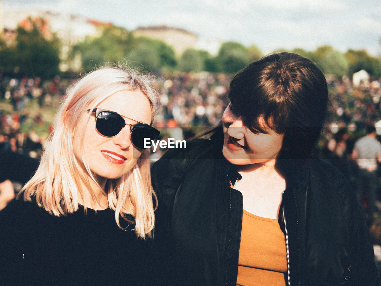 Portrait of beautiful young woman with friend in park