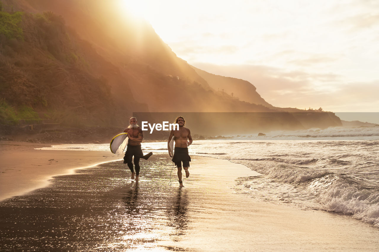 PEOPLE ON BEACH DURING SUNSET