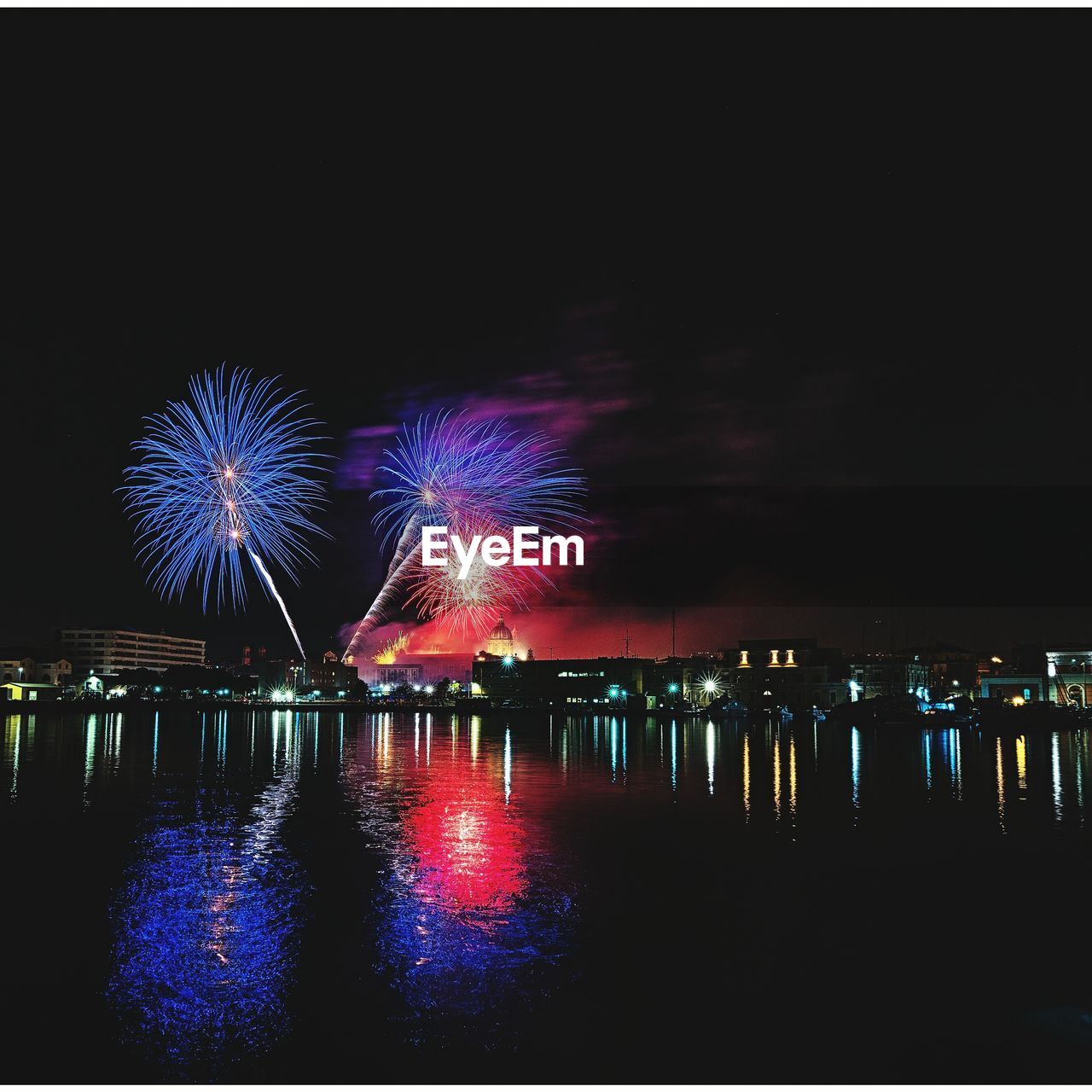 FIREWORK DISPLAY OVER RIVER AGAINST SKY