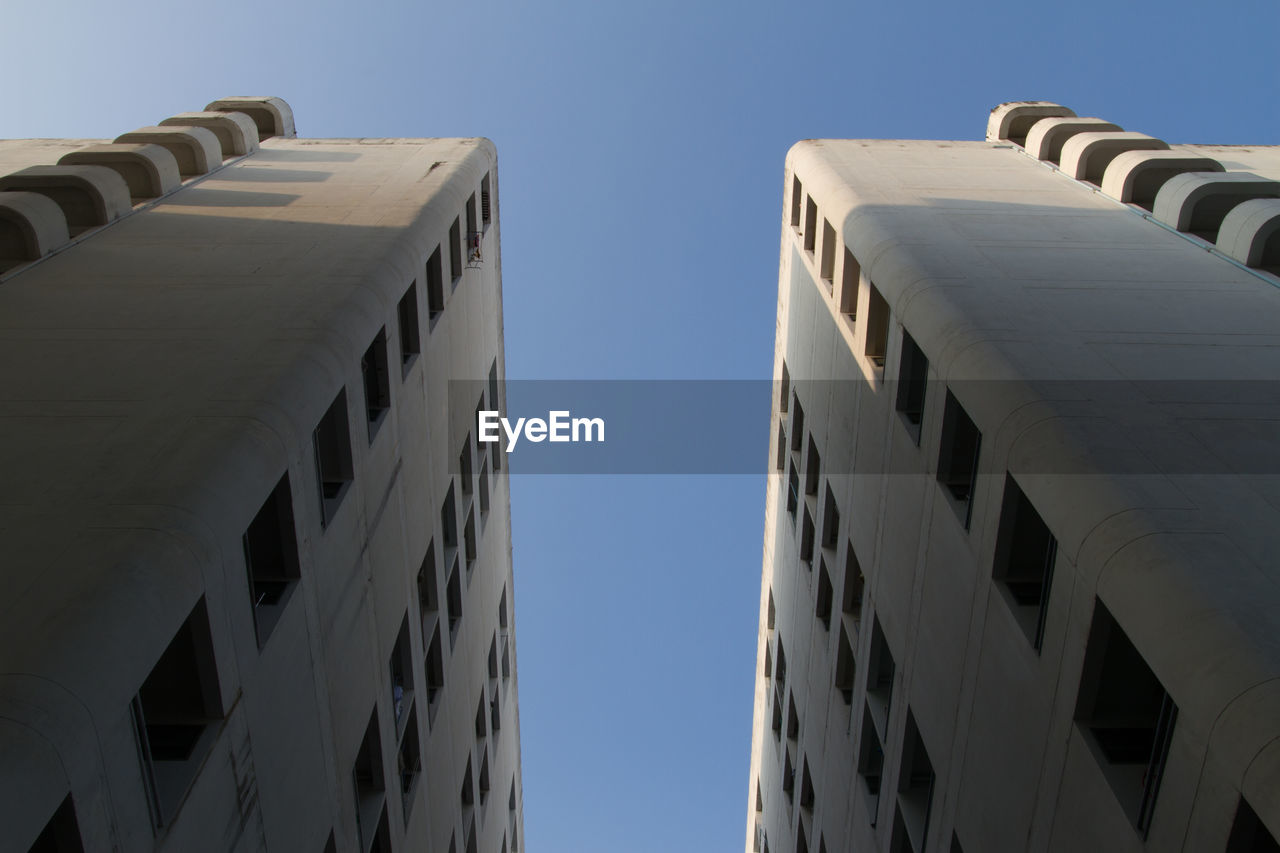 Low angle view of buildings against clear blue sky