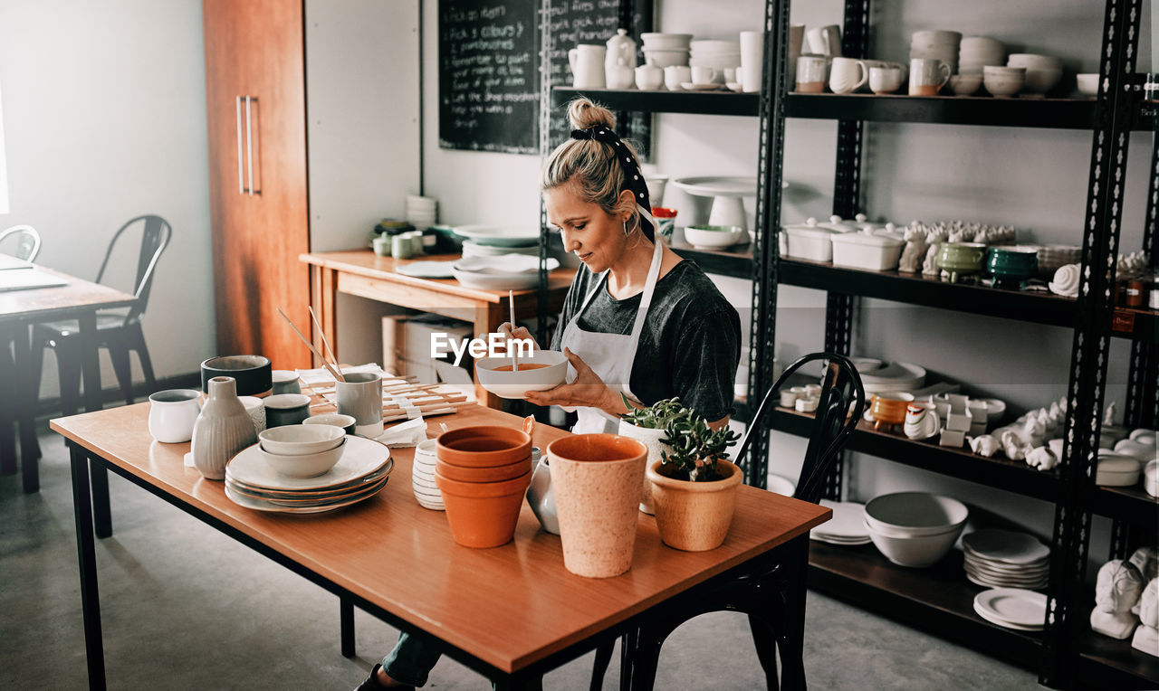 Woman sitting at table in workshop