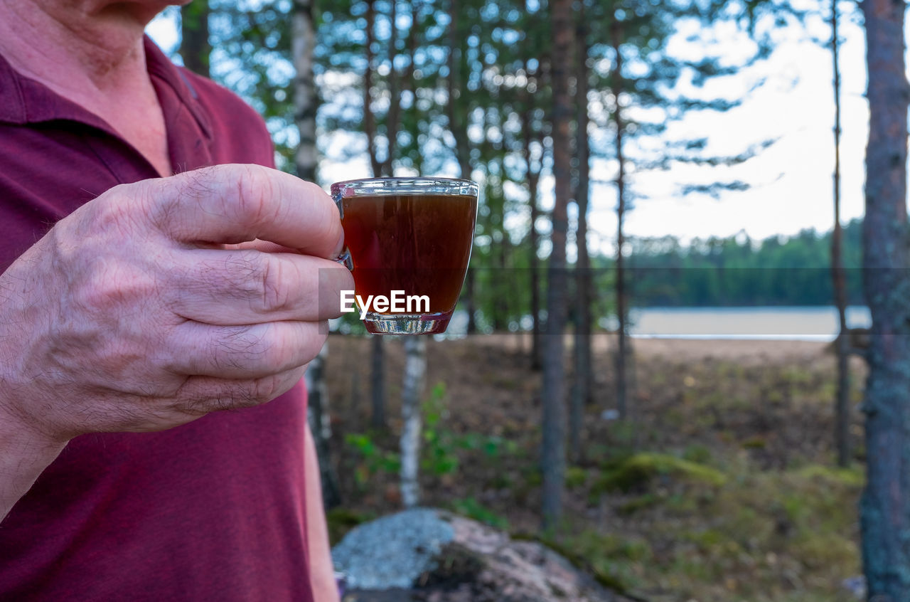 MIDSECTION OF MAN DRINKING GLASS ON RED WINE