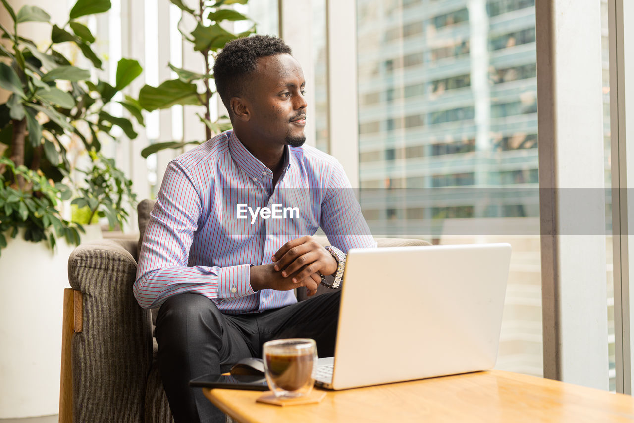 young man using laptop while sitting on sofa at office