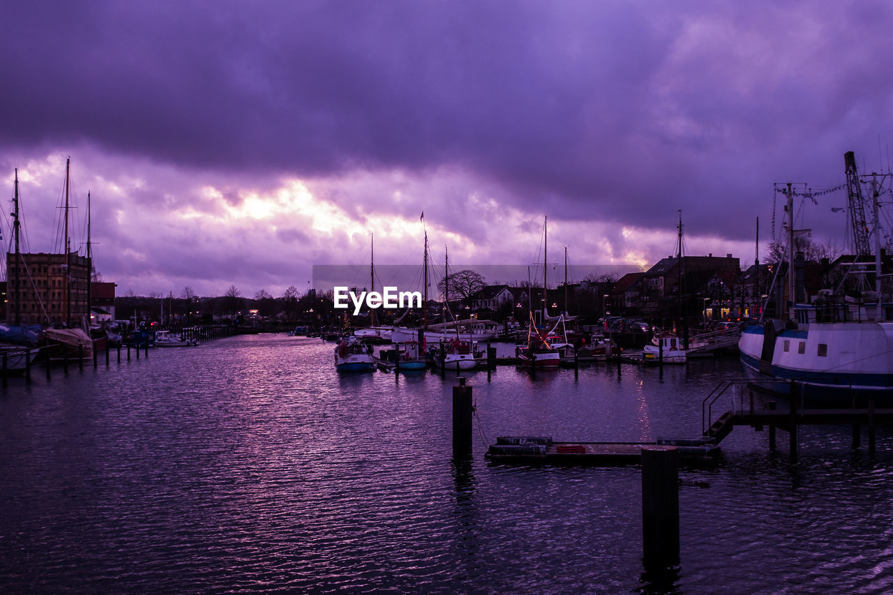 SAILBOATS IN CITY AT DUSK