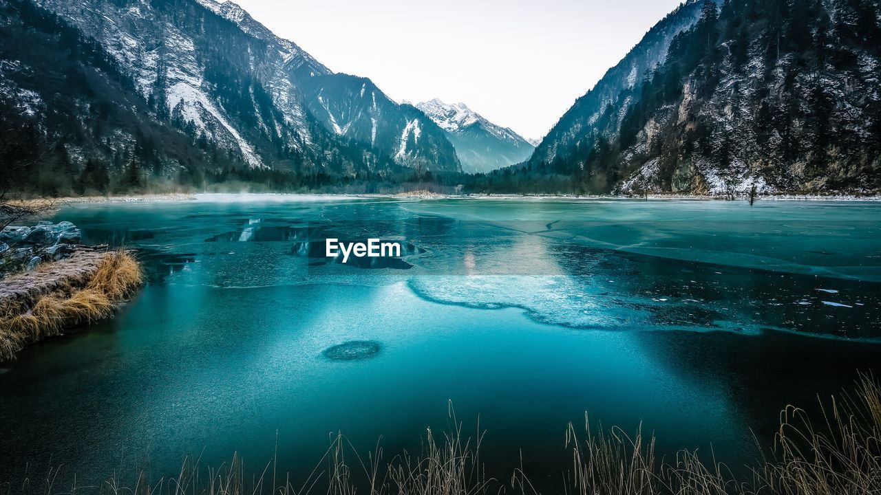 Frozen lake by mountains