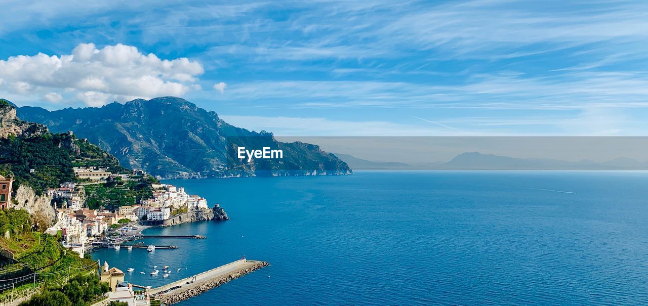 Scenic view of sea and mountains against sky