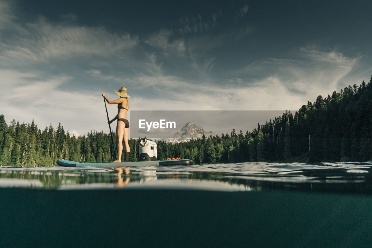 A young woman enjoys a standup paddle board on lost lake in oregon.