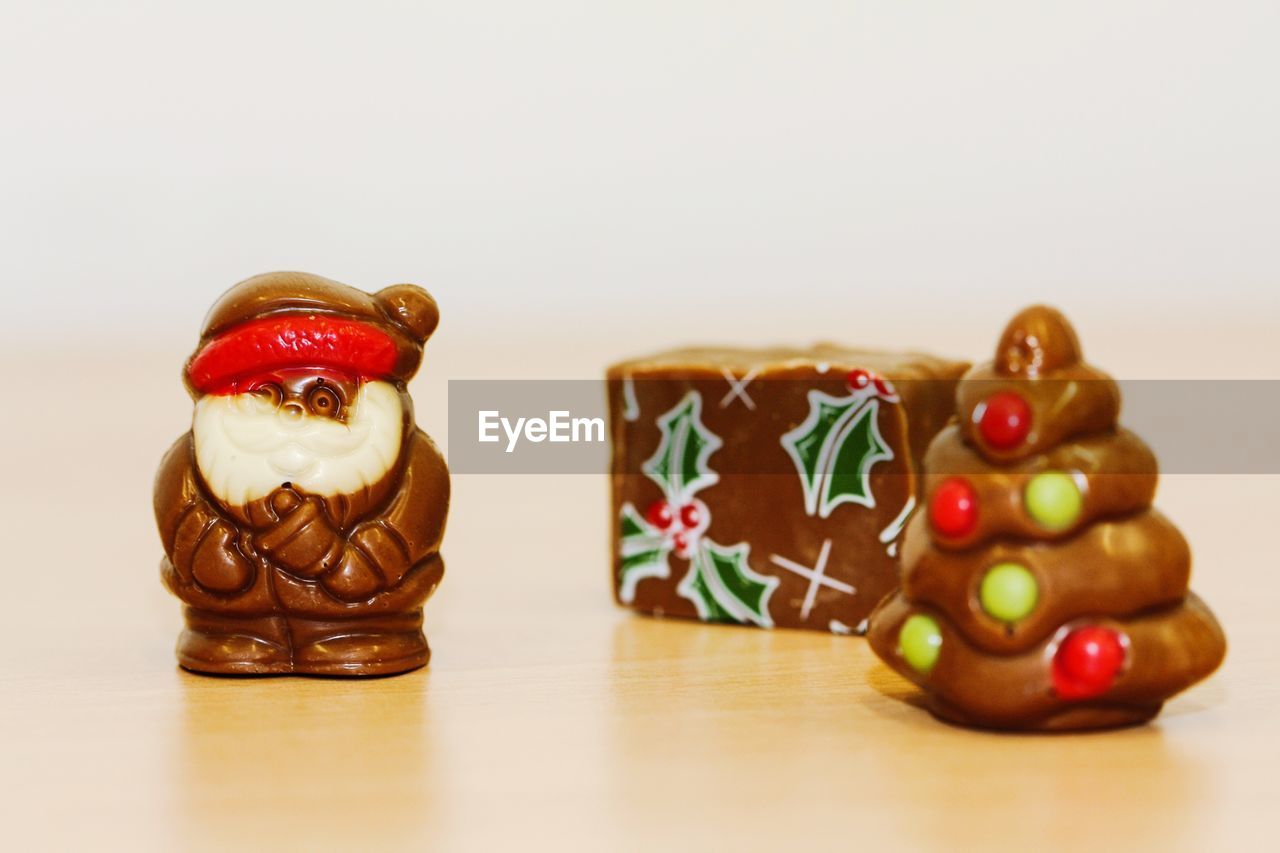 Close-up of chocolate figurine on table against white background