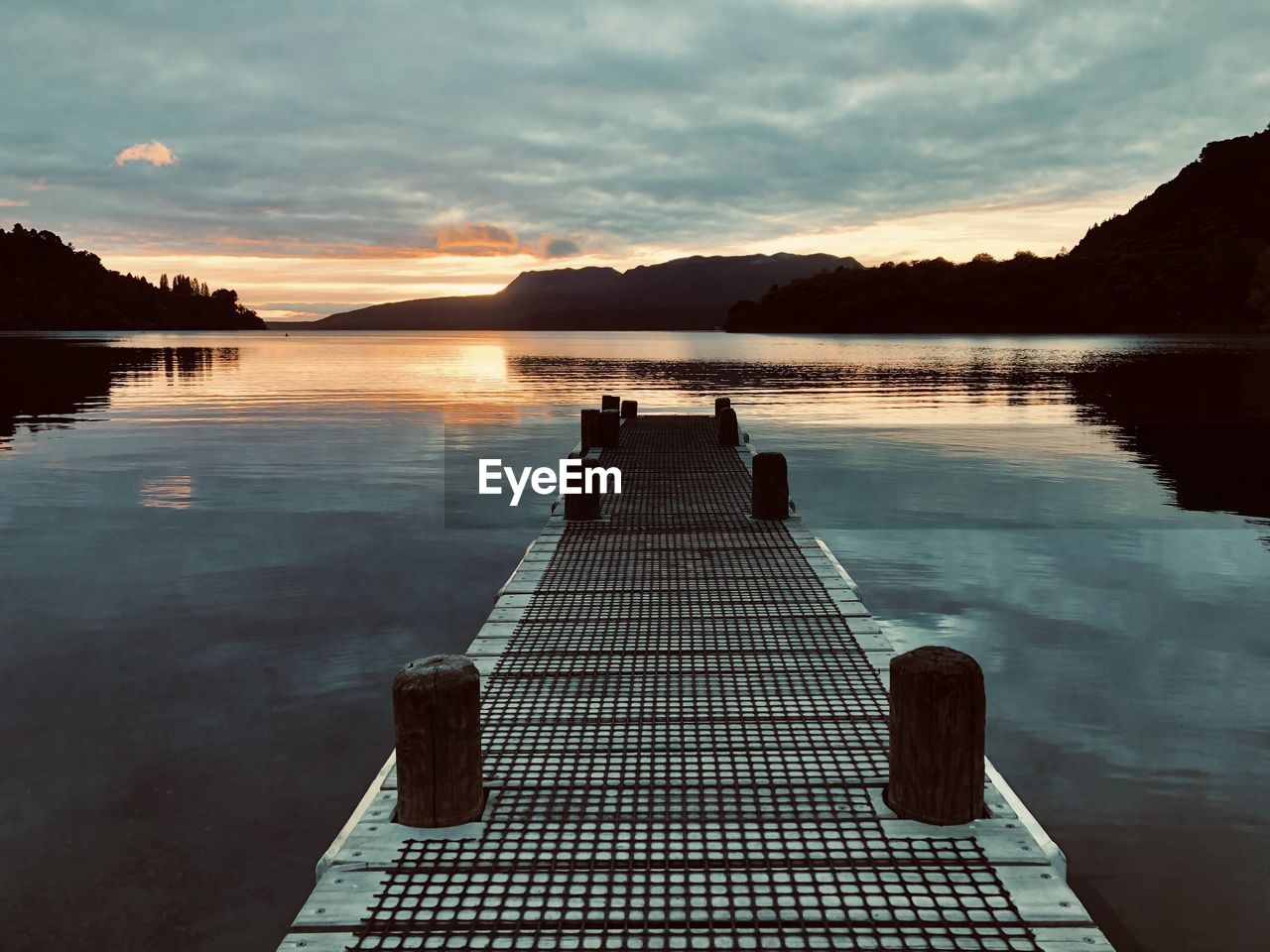 Pier on lake against sky during sunrise, lake tarawera new zealand 