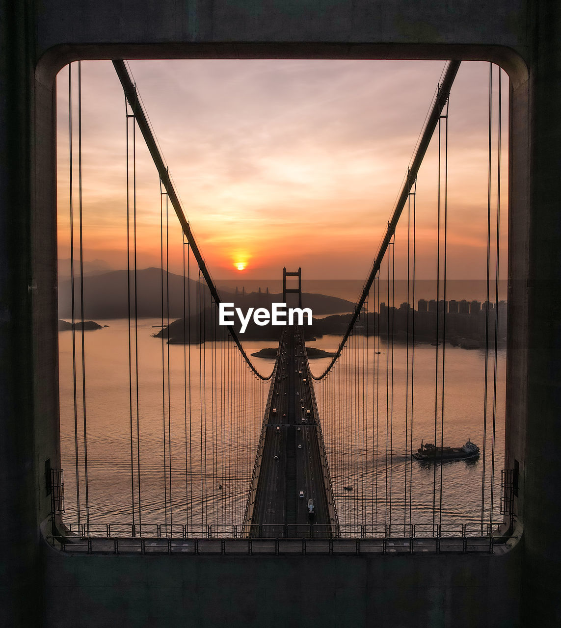 silhouette bridge over sea during sunset
