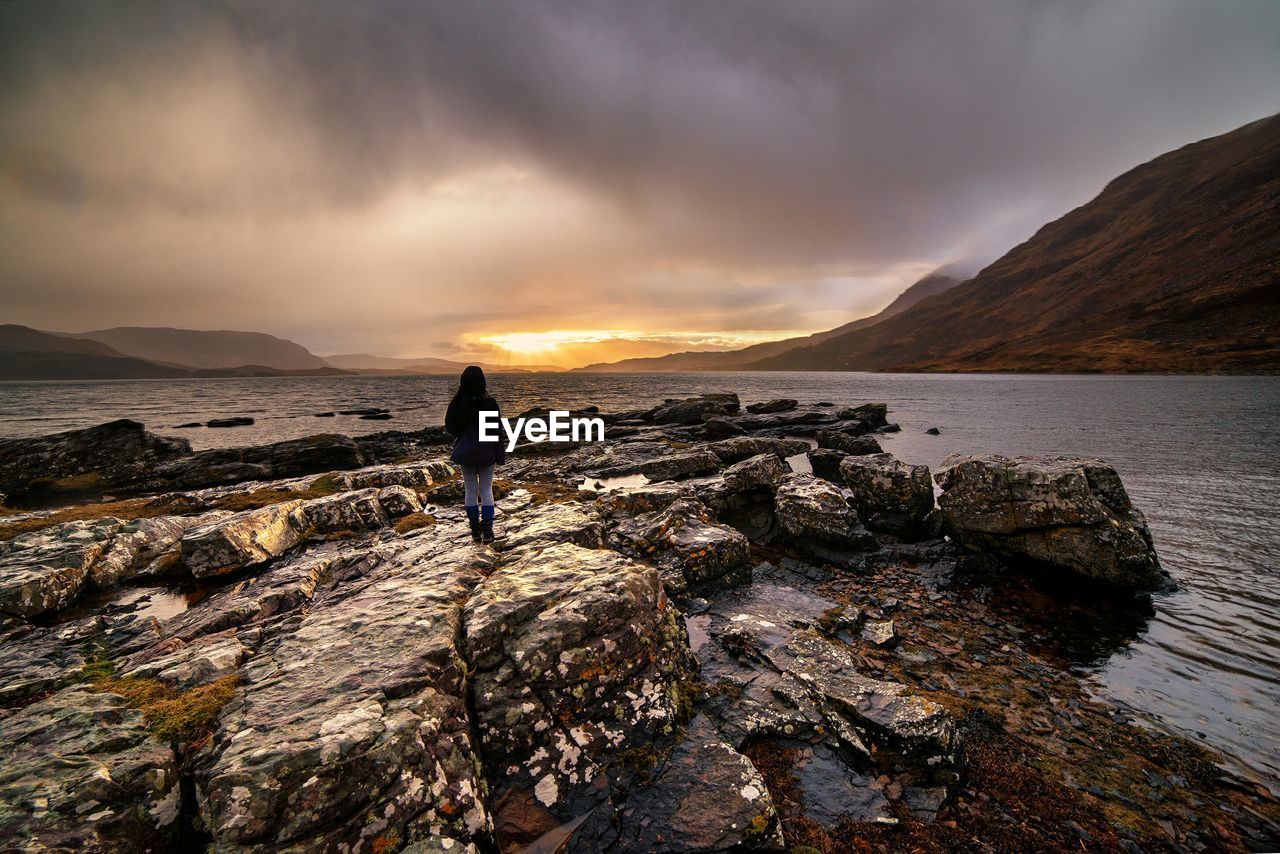 Rear view of woman overlooking calm sea