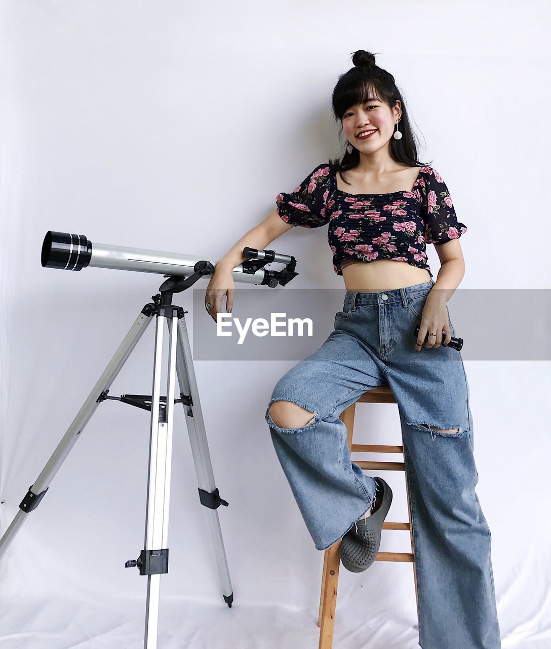 Portrait of woman sitting next to telescope 