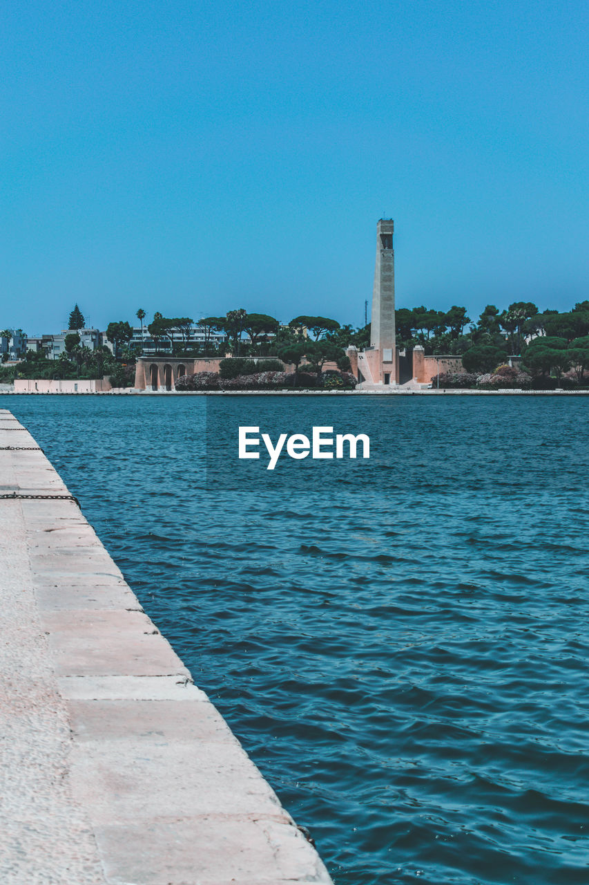 SCENIC VIEW OF SEA AGAINST BUILDINGS AGAINST CLEAR BLUE SKY