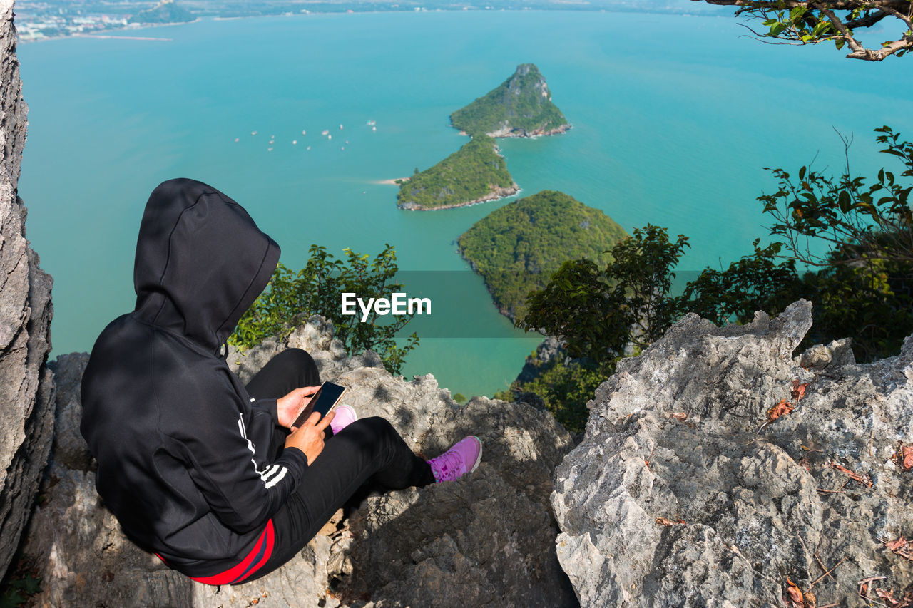 HIGH ANGLE VIEW OF WOMAN BY SEA