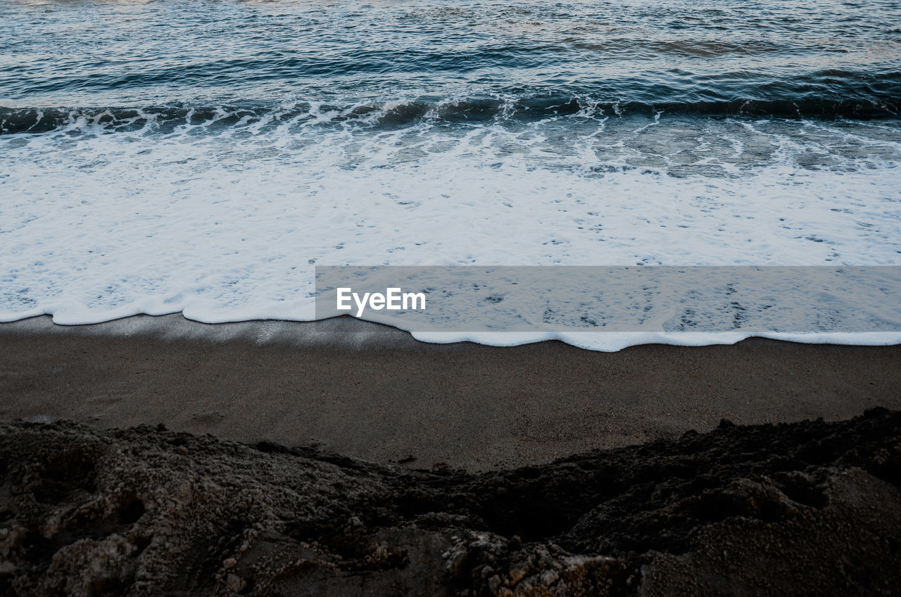 High angle view of surf on sea shore