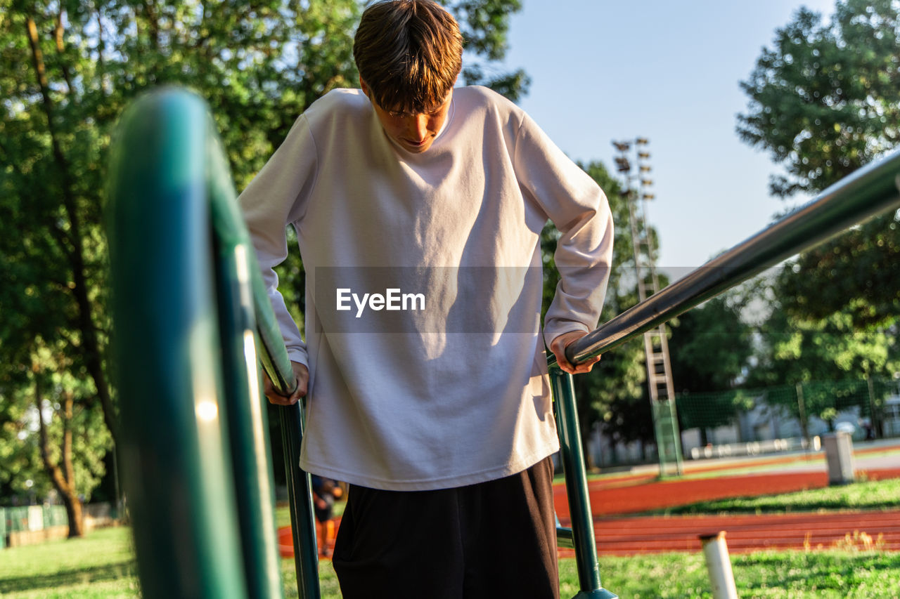 rear view of young woman standing on railing