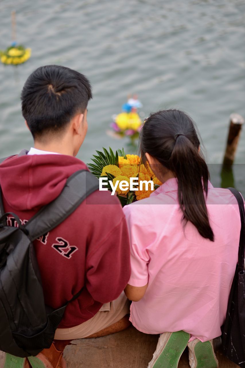 Rear view of siblings with religious offerings