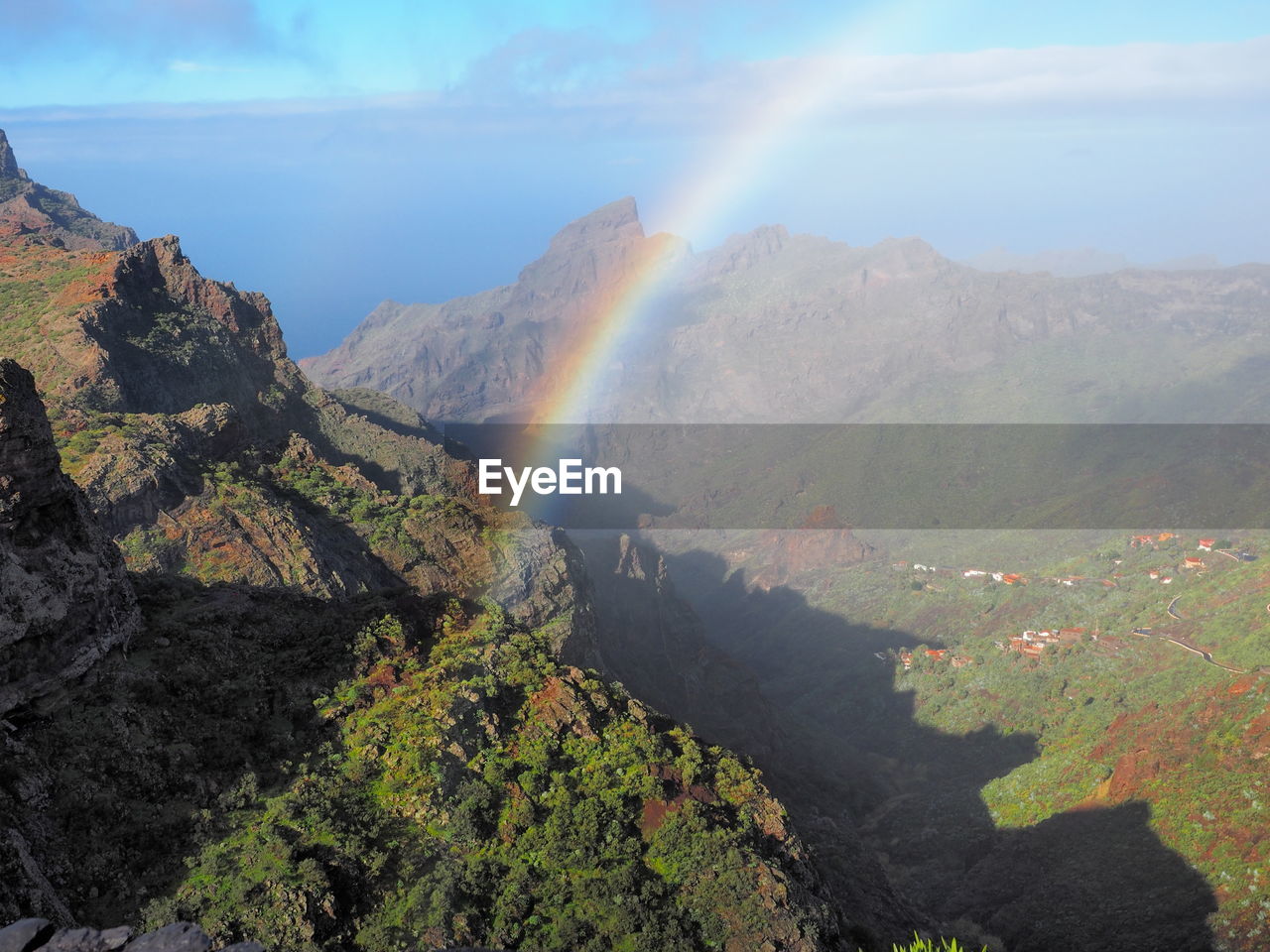 RAINBOW OVER MOUNTAINS AGAINST SKY