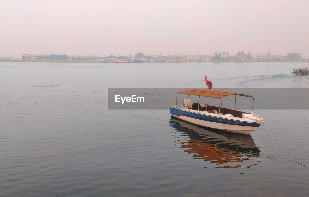 Boat in sea against sky during sunset