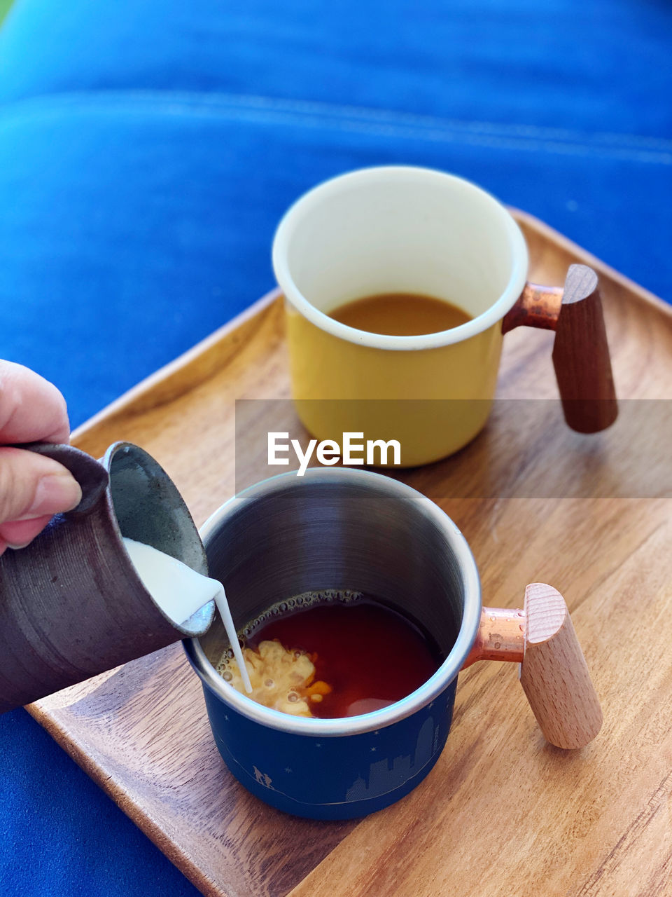 Cropped hand of woman holding coffee on table