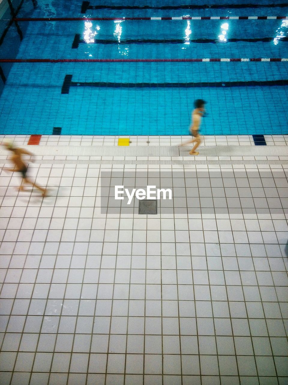 High angle view of shirtless boys running at poolside