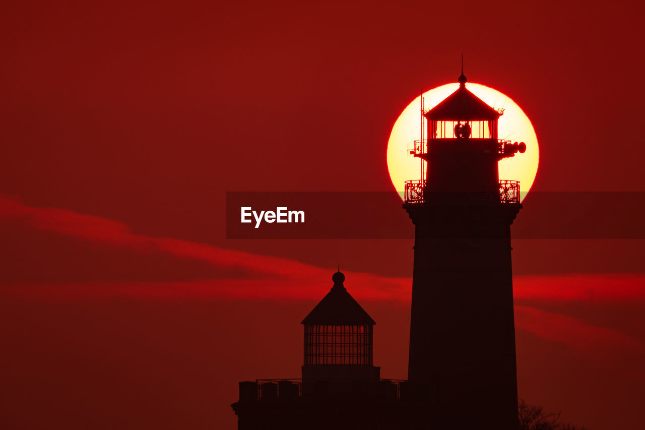 SILHOUETTE OF BUILDING AGAINST ORANGE SKY