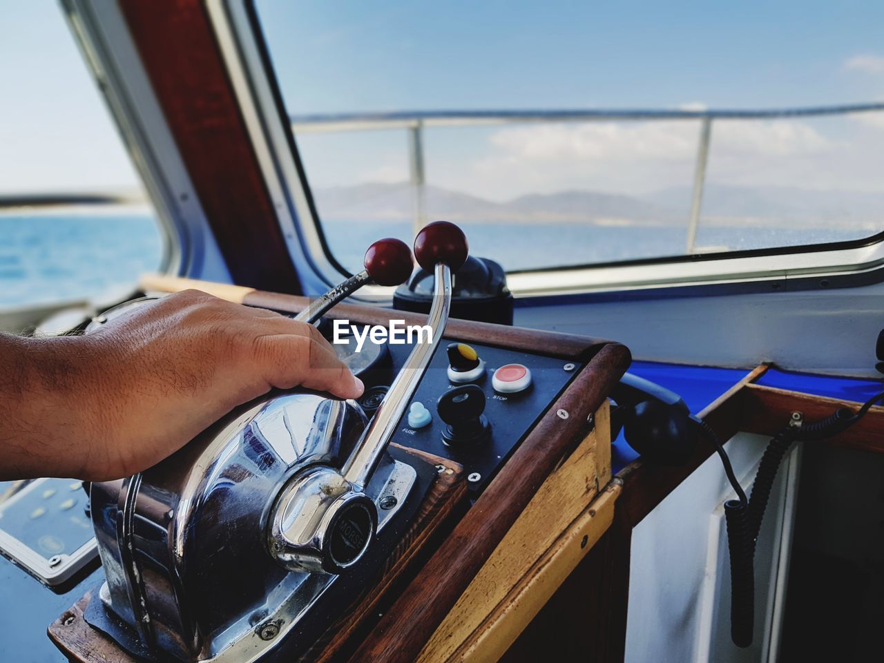Cropped hand of man on control panel in recreational boat