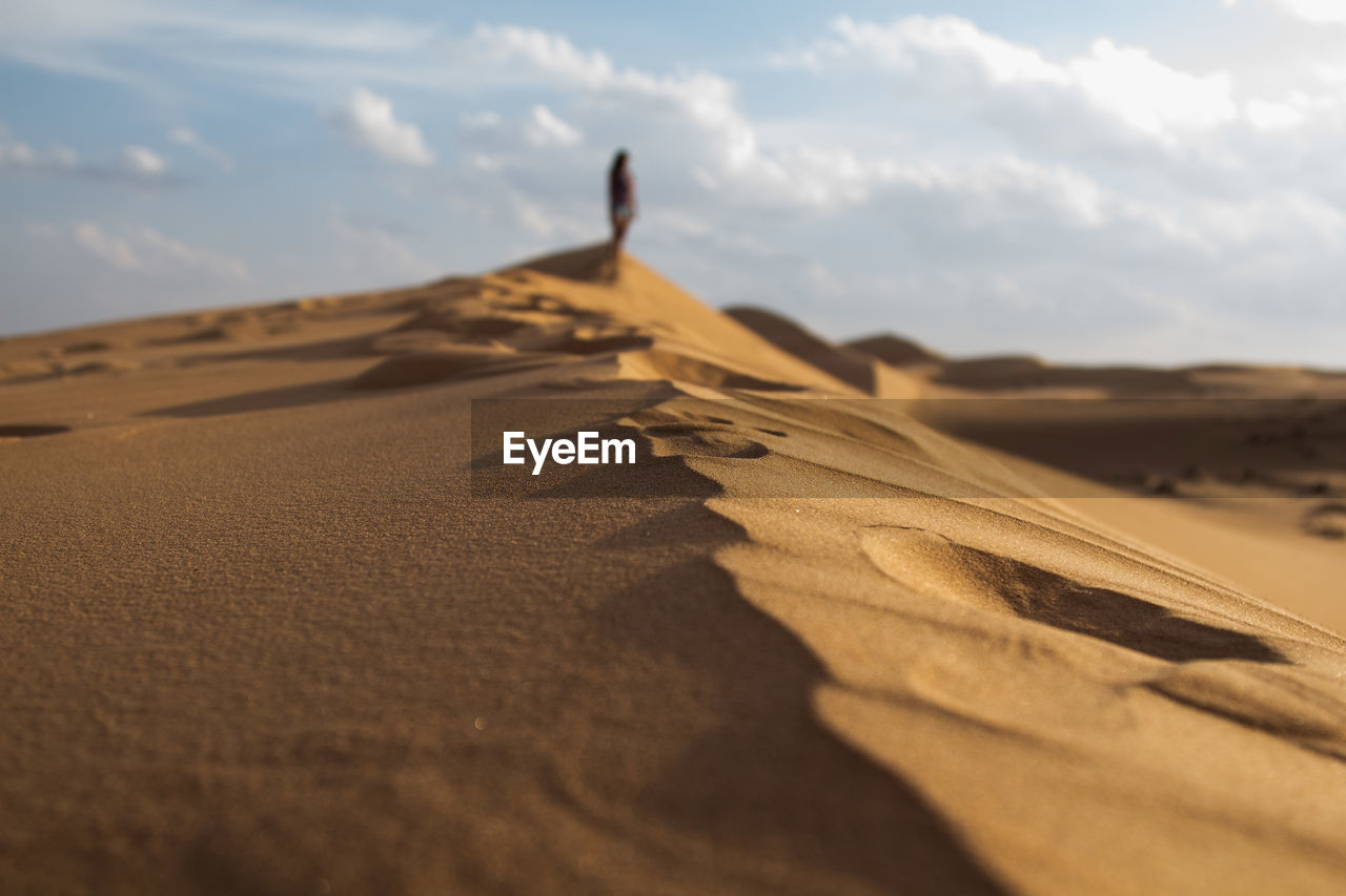 Distance shot of a person standing at desert