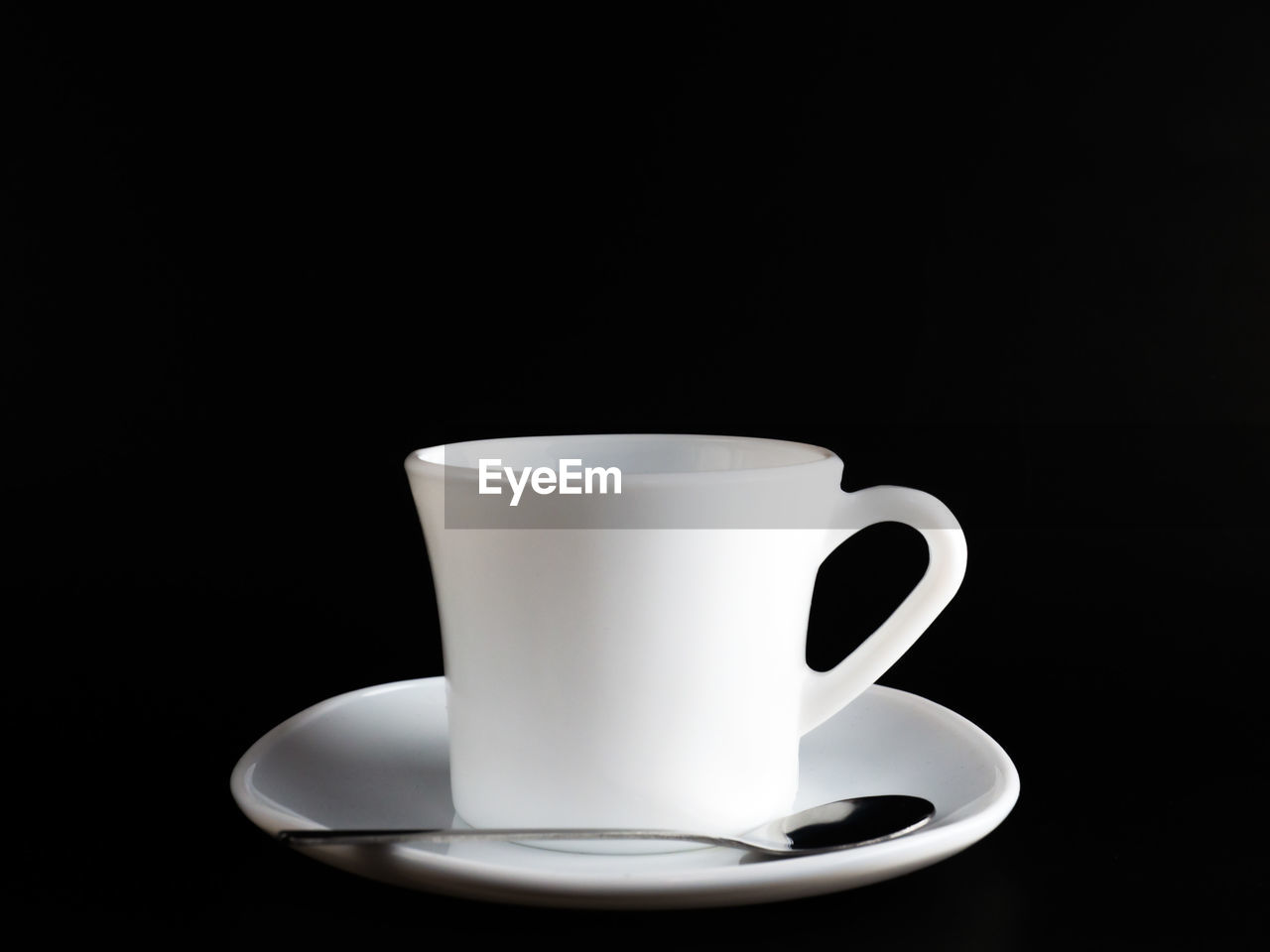 Close-up of coffee cup on table against black background