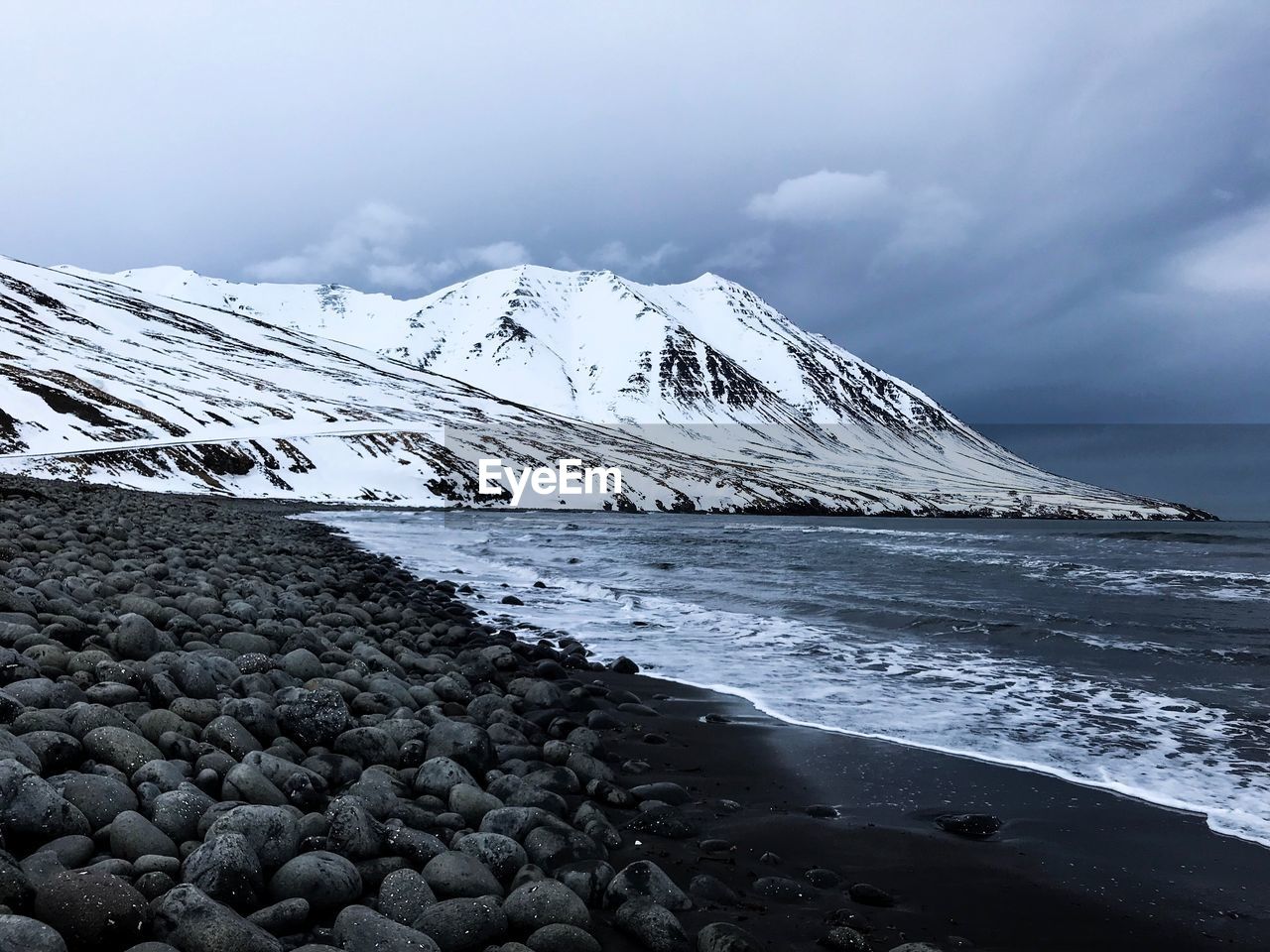 Scenic view of sea and snowcapped mountain against sky