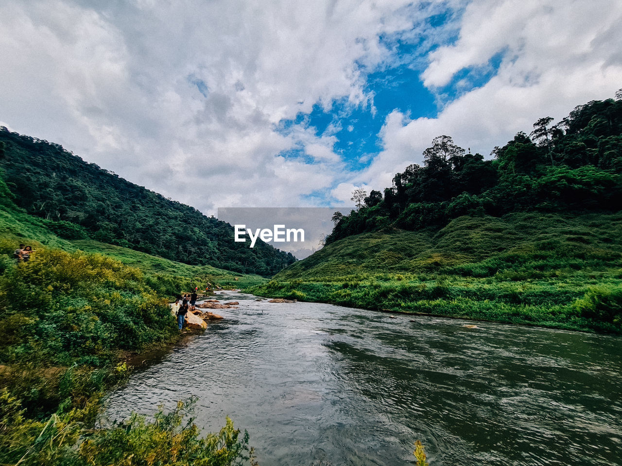 RIVER AMIDST TREES AGAINST SKY